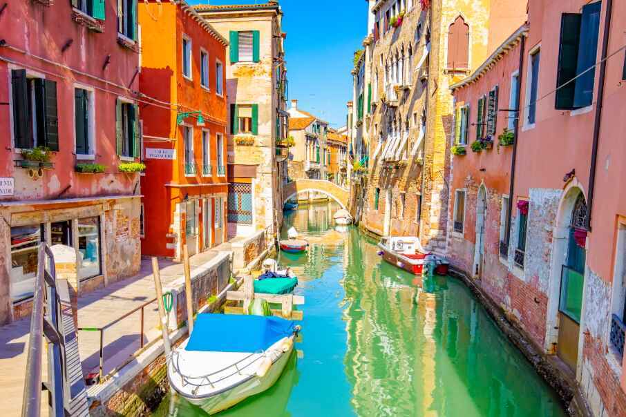 Colorful sunny street and water canal in Venice Italy