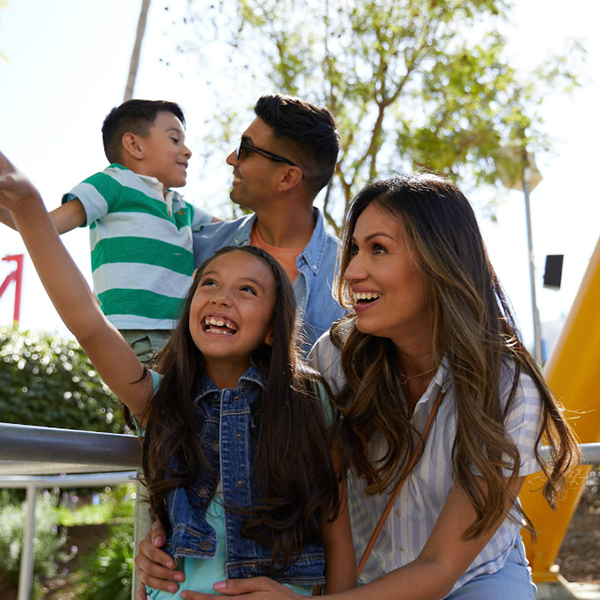 Girl points something out to her family while smiling