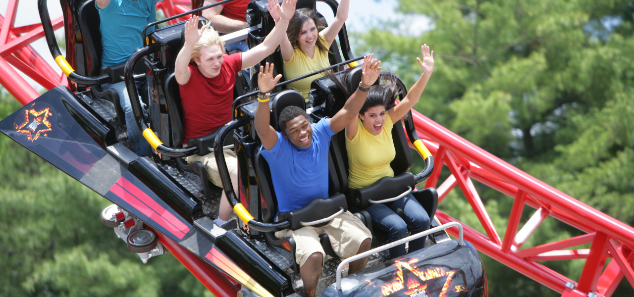 People ride a coaster with their hands up