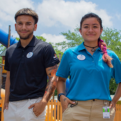 Two Six Flags Employees smile at the camera