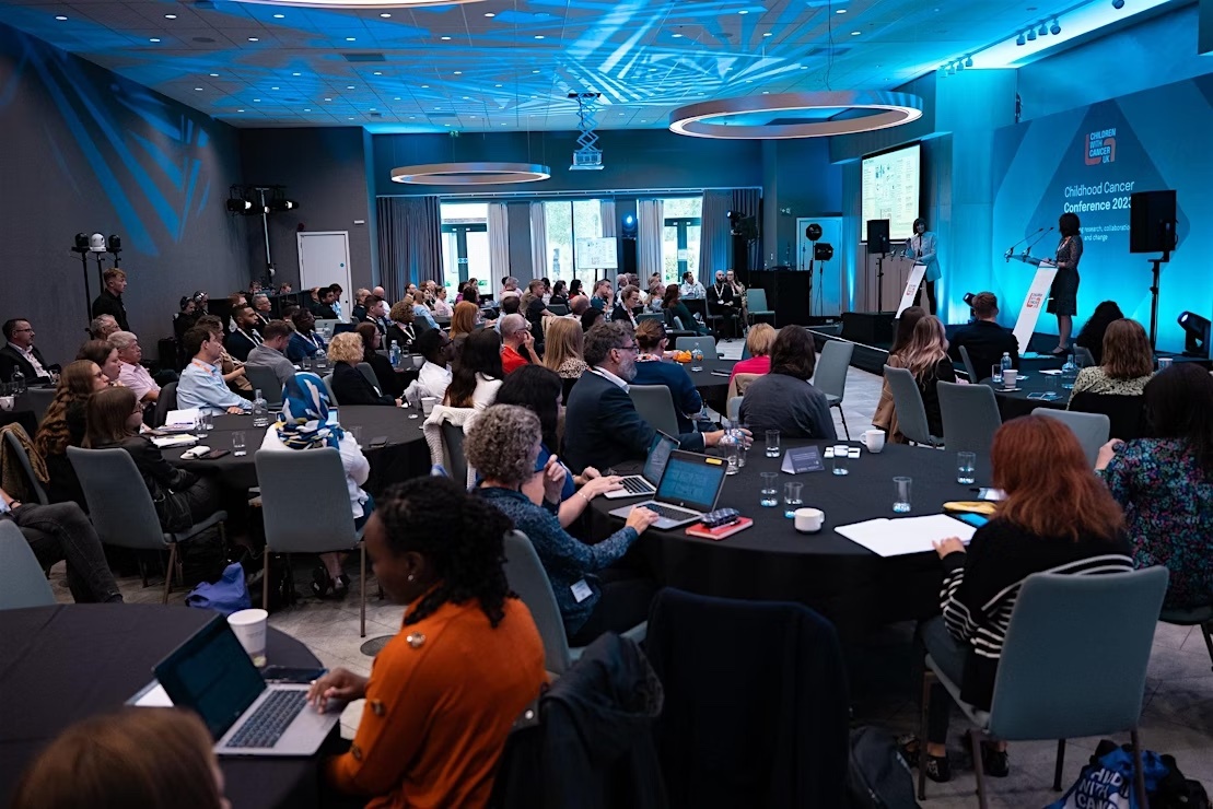 people sitting in a conference watching a speaker